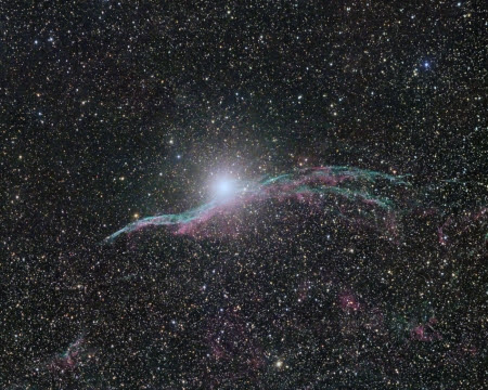 The Veil Nebula is one of my favorite targets due to its beauty and detail. The different gases of Hydrogen and Oxygen emit wispy filaments of blue and red that appear intertwined. A brilliant star, 52 Cyg, tries to steal the show from its perch on the peak of the veil. Also known as the Witch's Broom, the Veil is only a small part of a much larger structure called the Cygnus Loop, the aftermath of a supernova estimated to have been visible from Earth 10,000 years ago.