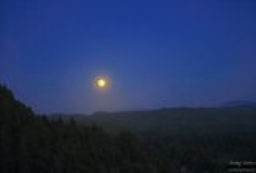 The moon hangs low on the Oregon coast.