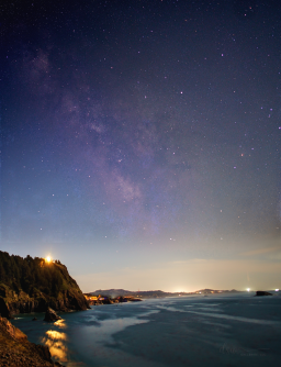On a night I spent taking photos from a bluff in Otter Rock, Oregon, I was surprised to see the Milky Way lurking above the city lights and behind the light pollution. A single frame captured enough to show it in this picture facing almost directly south looking down the coast and past Gull Rock and the Yaquina Head Lighthouse.