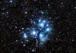 A long exposure reveals the wispy tendrils of nebulosity that surround the major stars in M45 like a cocoon.